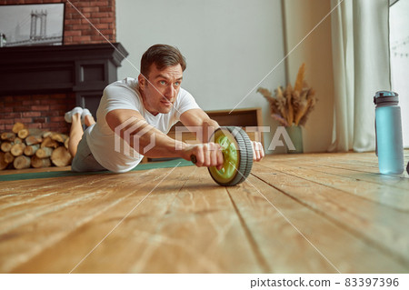 Man using outfit for exercising core indoors Man using outfit for exercising core indoors 83397396