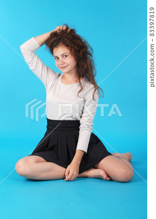 Young girl sitting on floor Young girl sitting on floor 83397819