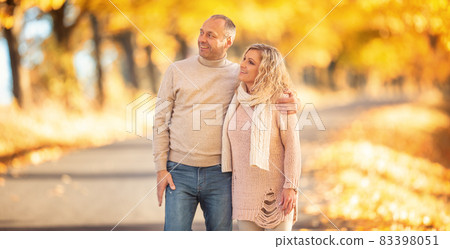 An adult couple in love on a walk in the autumn golden alley An adult couple in love on a walk in the autumn golden alley 83398051