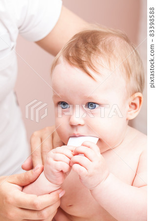 Little baby receiving osteopathic treatment of her arm 83398588