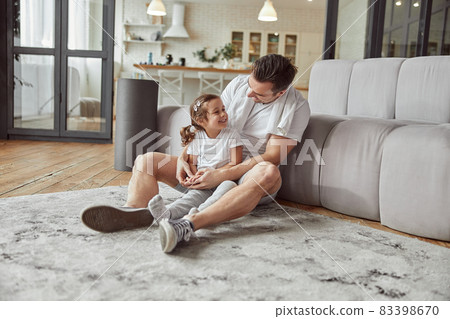 Happy father hugging his daughter in cozy apartment 83398670