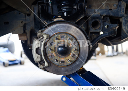 The wheel hub of the car with removed the wheel for brake and tire maintenance, the car jack lifting the car for service 83400349
