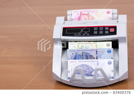 Uzbekistani money - som in a counting machine 83400376