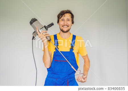 The master at the construction site with a construction mixer 83400835