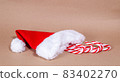 Christmas candy cane and red cap on craft background 83402270
