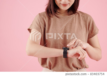 Woman Reading Message on Smartwatch Woman Reading Message on Smartwatch 83403754