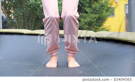 young woman is jumping on a babut, a close-up. Legs float in the air after jumping on a trampoline young woman is jumping on a babut, a close-up. Legs float in the air after jumping on a trampoline 83404565