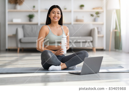 Portrait Of Smiling Young Asian Woman Training With Laptop Computer At Home 83405988
