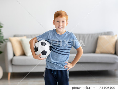 Happy preteen boy posing with soccer ball at home Happy preteen boy posing with soccer ball at home 83406300