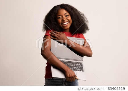Tech Lover Concept. Cheerful Black Lady Hugging Laptop With Blank Screen 83406319