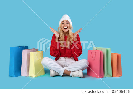 Overjoyed lady sitting with shopping bags at studio Overjoyed lady sitting with shopping bags at studio 83406406