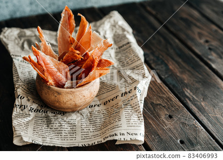 Dried chicken, dried poultry, cut into strips on parchment and wooden background. Served with ajiga or ketchup 83406993