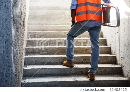 Professional builder carrying metal ladder, close up Professional builder carrying metal ladder, close up 83408415