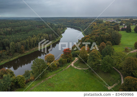 Punia mound in Lithuania with green grass and autumn trees background, road to mountain 83409966