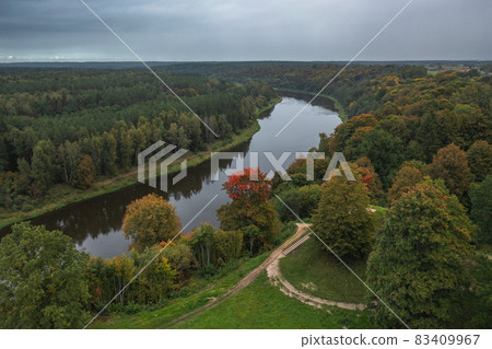 Punia mound in Lithuania with green grass and autumn trees background, road to mountain 83409967