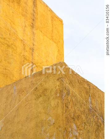 rough plastered painted yellow wall and blue sky rough plastered painted yellow wall and blue sky 83410156