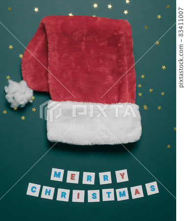 Red santa's cap on a flatlay Christmas composition. Festive postcard. Merry Christmas Red santa's cap on a flatlay Christmas composition. Festive postcard. Merry Christmas 83411007