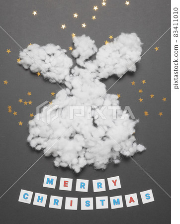 Christmas card with a white wadded angel and an inscription lined with paper letters. Layout composition Christmas card with a white wadded angel and an inscription lined with paper letters. Layout composition 83411010