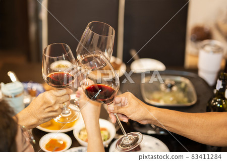 Family toasting with glasses of red wine at dinner party. Family toasting with glasses of red wine at dinner party. 83411284