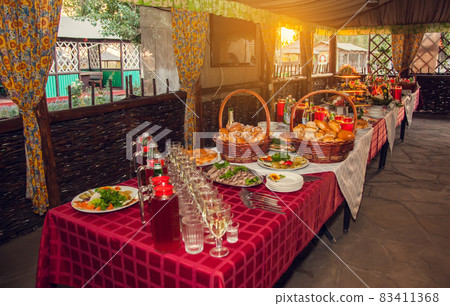 Russian feas. A table set with Russian snacks - pies with stuffing, pickles, drinks poured into glasses. Russian feas. A table set with Russian snacks - pies with stuffing, pickles, drinks poured into glasses. 83411368