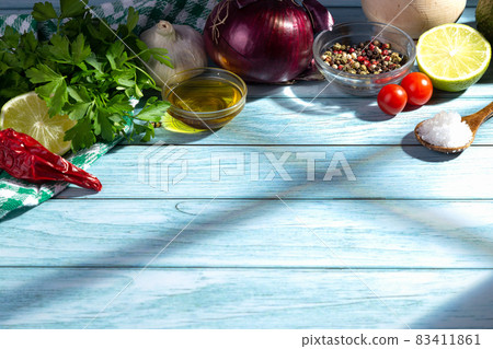 Fresh ingredients for cooking on blue wooden table with shadows coming through the kitchen window.  with copy space. 83411861