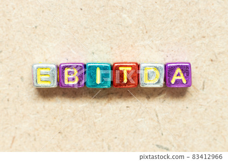 Metallic color alphabet letter block in word EBITDA (abbreviation of earnings before interest, taxes, depreciation and amortization) on wood background 83412966