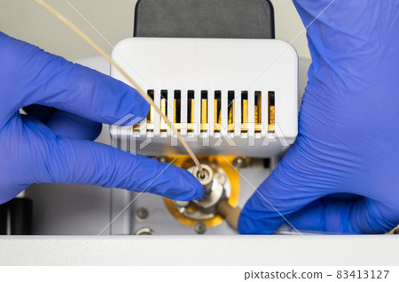 Chemist inzert a nebuliser into ion source of mass spectrometer. Liquid chromatography with mass detector. Maintenance of the instrument. 83413127
