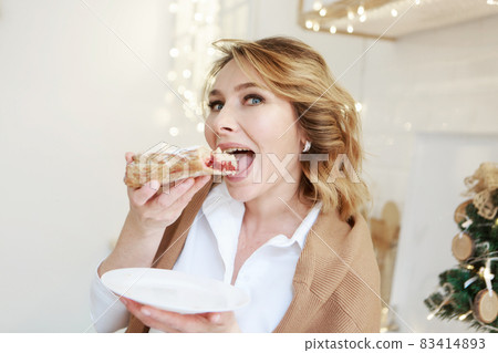 home delivery. The hostess is eating a pie for Christmas dinner. New Year's holidays home delivery. The hostess is eating a pie for Christmas dinner. New Year's holidays 83414893
