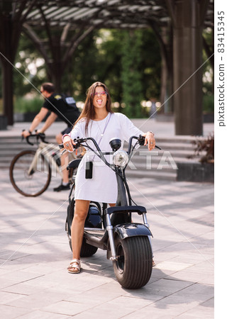 Young beautiful woman teasing and showing tongue at camera in park 83415345