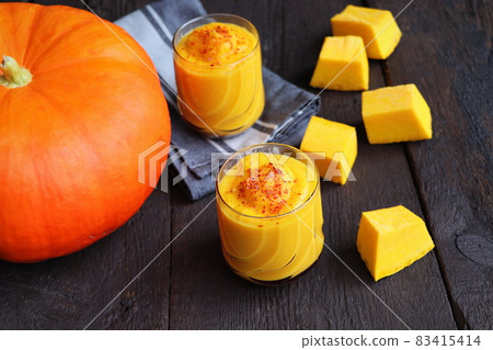 Pumpkin smoothie with spices on a wooden background Top view. Copy space Pumpkin smoothie with spices on a wooden background Top view. Copy space 83415414