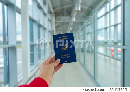 Ukrainian passport in hand at the airport before departure. Travel time 83415725