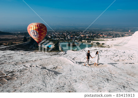 Couple in love among balloons. Couple in love in Pamukkale. Couple in Turkey. Honeymoon trip. A man and a woman are traveling. Flying on balloons. Couple travels the world. Vacation in Turkey Couple in love among balloons. Couple in love in Pamukkale. Couple in Turkey. Honeymoon trip. A man and a woman are traveling. Flying on balloons. Couple travels the world. Vacation in Turkey 83415913