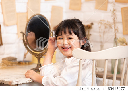 Girl playing in an antique mirror Girl playing in an antique mirror 83418477