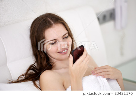 European woman is chatting with friends by phone in bed. European woman is chatting with friends by phone in bed. 83421170
