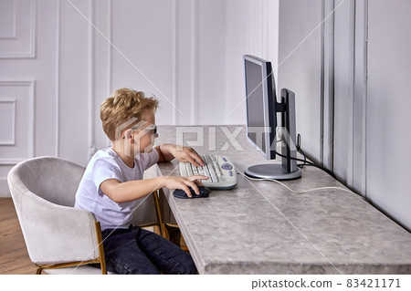 Desktop computer with little boy during e-learning during pandemic. Desktop computer with little boy during e-learning during pandemic. 83421171