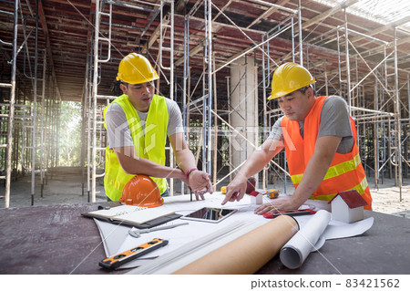 Confident team of architect working together in building construction site. They discussing about new startup project. Architect discuss with engineer about project . Architectural concept. 83421562