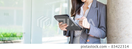 Working woman concept a young businesswoman working online on her business with the handle devices, tablet, outside the workplace 83422314