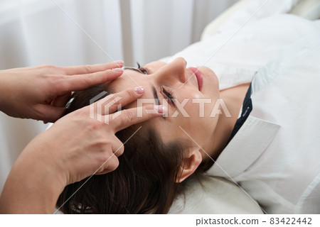 Beautiful Young Woman Getting a Face and head Treatment at Beauty Salon Beautiful Young Woman Getting a Face and head Treatment at Beauty Salon 83422442