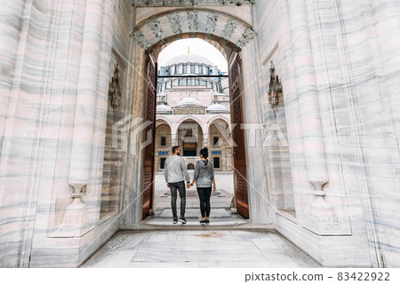 Traveling couple near the mosque. Beautiful mosque in Istanbul. Wedding trip the newlyweds. Tourists in Turkey. Follow me. Boy and girl holding hands. Tourists on the tour. Man and woman in the mosque 83422922