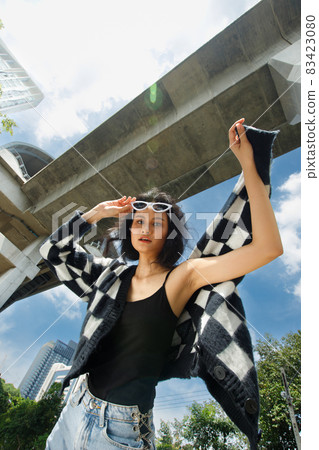 Portrait of 20s Asian Woman brown hair wear jacket high fashion make up under blue sky cloud Portrait of 20s Asian Woman brown hair wear jacket high fashion make up under blue sky cloud 83423080