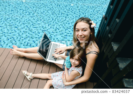 Close-up of female mother, daughter and laptop on background of 83424037