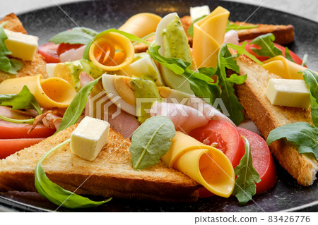 Closeup view of toast, ham, boiled egg, cheddar and tomato 83426776