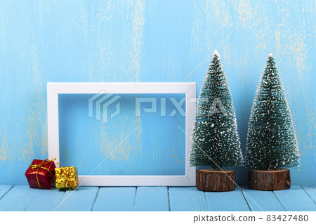 Frame and Christmas trees on a blue background Frame and Christmas trees on a blue background 83427480