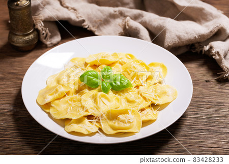 plate of ravioli with parmesan and green basil 83428233