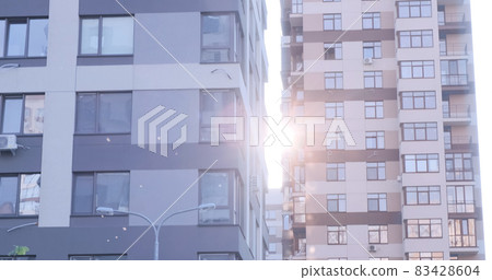 Residential building apartments windows at sun day. Modern building facade. Rent, purchase, sale of new housing concept. Multistory apartment building in urban area Residential building apartments windows at sun day. Modern building facade. Rent, purchase, sale of new housing concept. Multistory apartment building in urban area 83428604