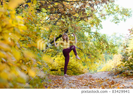 Woman make stretching in autumn scenic forest 83429941