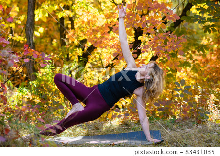 Woman exercise yoga balance at autumn forest Woman exercise yoga balance at autumn forest 83431035