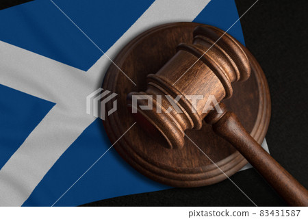 Judge Gavel and flag of Scotland. Law and justice in Scotland. Violation of rights and freedoms Judge Gavel and flag of Scotland. Law and justice in Scotland. Violation of rights and freedoms 83431587