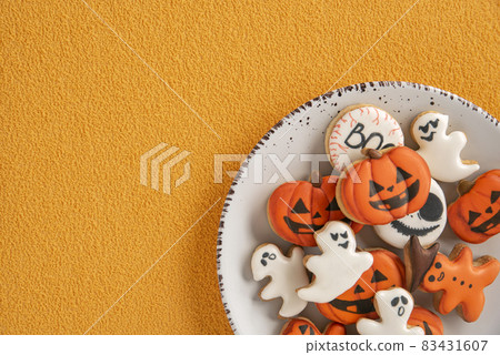 Delicious gingerbread for Halloween in a white plate, orange background. Space for text. Pumpkin and ghosts. Copy space Delicious gingerbread for Halloween in a white plate, orange background. Space for text. Pumpkin and ghosts. Copy space 83431607