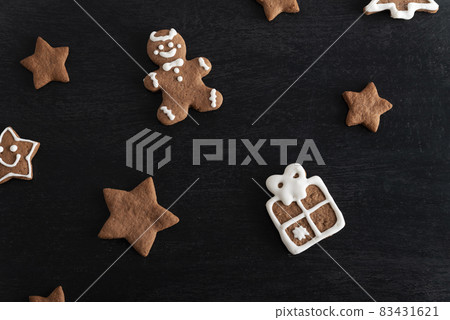 Gift box and stars from gingerbread on black background. Traditional pastries 83431621